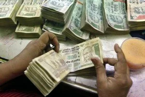 An employee counts Indian currency notes at a cash counter inside a bank in Kolkata June 18, 2012. The Indian rupee gained in early trade on Monday as risk assets rallied after Greece elections gave a slim majority to pro-bailout parties, with the focus shifting to the central bank policy decision later in the day. REUTERS/Rupak De Chowdhuri (INDIA - Tags: BUSINESS)